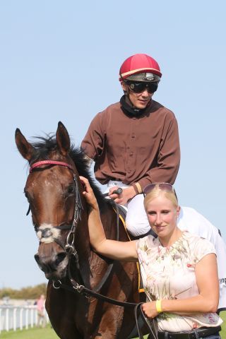 Zamrud nach ihrem Iffezheimer Sieg unter Bauyrzhan Murzabayev, Trainerin Sarah Steinberg am Führzügel. www.galoppfoto.de