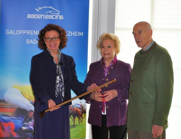Jutta Hofmeister, Geschäftsführerin von Baden Racing, überreicht die Goldene Peitsche für den Sieg von Donnerschlag an Edith und Manfred Hellwig (v.l.). www.baden-racing.com 