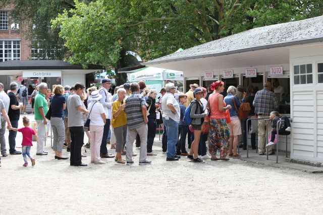 Die Senkung der Abzüge von 25 auf 15 Prozent soll die Pferdewetter wieder attraktiver machen: Rennbahnbesucher stehen an den Wettkassen in Hoppegarten an. www.galoppfoto.de - Frank Sorge