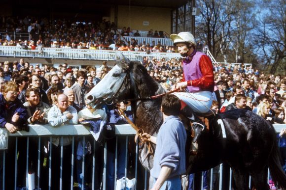 Historical moment: “German-German Raceday” on March 31st 1990, when East German horses raced against West Germans for the first time since the war. East-Jockey Lutz Pyritz with Rubin in front of the grandstand. www.galoppfoto.de